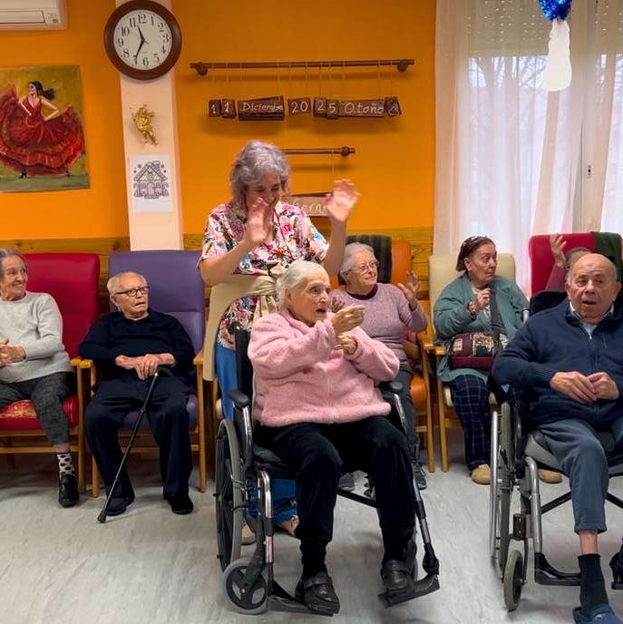 Residentes aplaudiendo sentados en círculo durante un taller de risoterapia