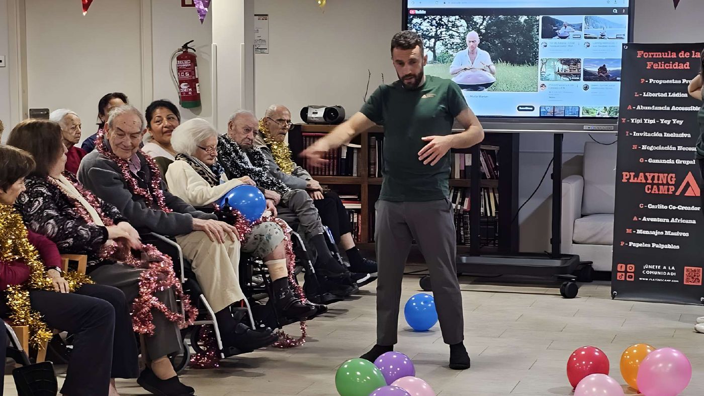 Taller de risoterapia con globos en una residencia: residentes sentados en círculo y el facilitador en el centro